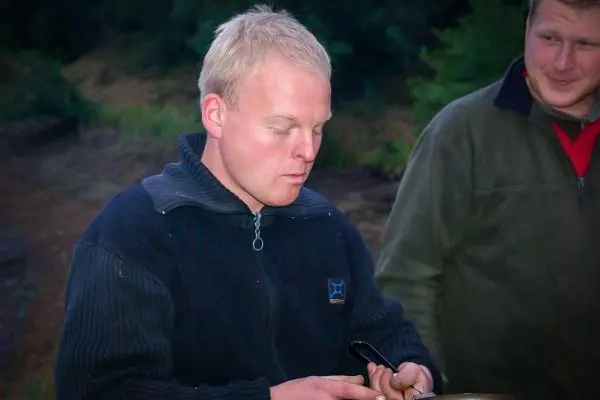 Zwei Personen stehen am Kochen, einer hält einen Löffel in der Hand