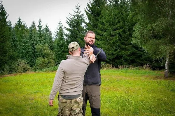 Zwei Personen üben eine Selbstverteidigungstechnik im Freien