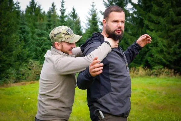 Zwei Personen üben eine Selbstverteidigungstechnik im Freien