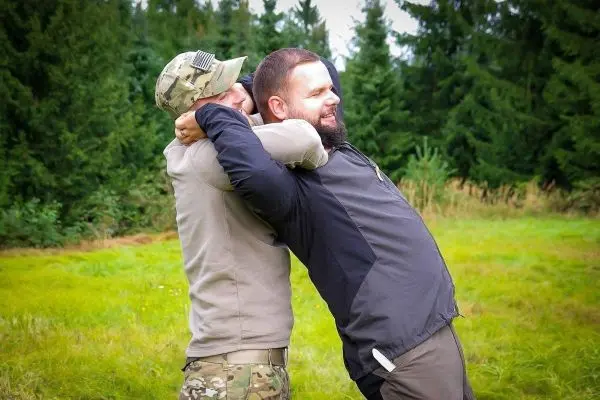 Zwei Personen üben eine Technik zur Kontrolle des Gegners im Freien