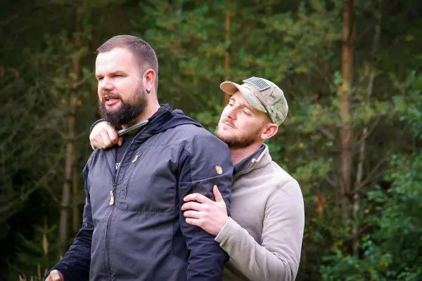 Zwei Personen üben eine Technik zur Kontrolle in einer natürlichen Umgebung