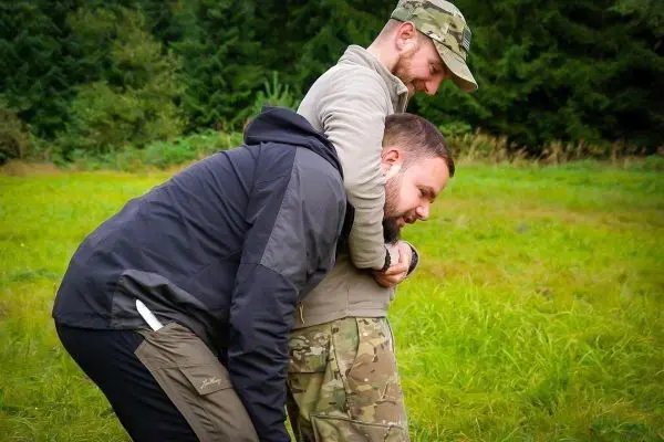 Zwei Personen üben eine Technik zur Unterstützung in einer Wiese