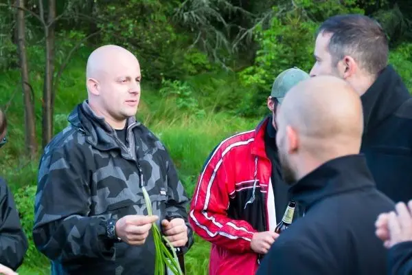 Gruppendiskussion im Freien mit einem Mann, der Pflanzen in der Hand hält