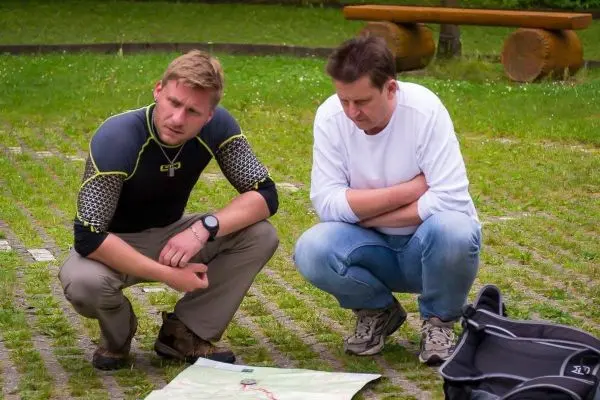 Zwei Personen betrachten eine Karte auf dem Boden und diskutieren