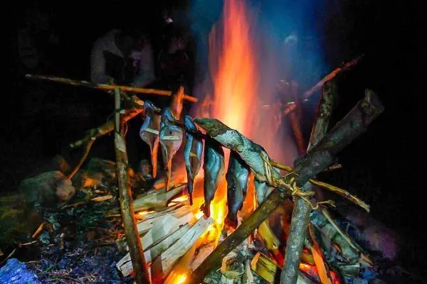 Fische werden über einem offenen Feuer geräuchert
