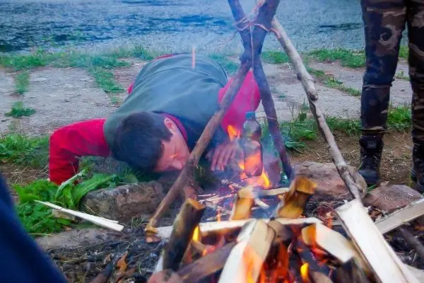 Kopf über dem Feuer, um Wasser in einer Flasche zu erhitzen