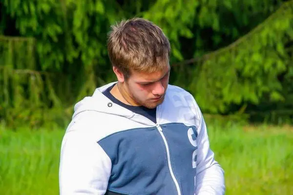 Person schaut nach unten und haelt etwas in der hand