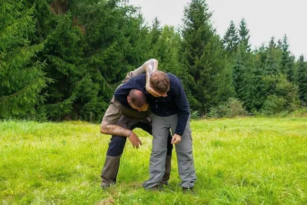 Zwei Personen führen eine Technik zur Unterstützung in einer Wiese durch