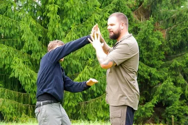 Zwei Personen üben eine Selbstverteidigungstechnik im Freien