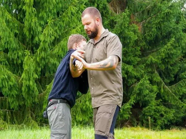 Zwei Personen üben eine Selbstverteidigungstechnik im Freien