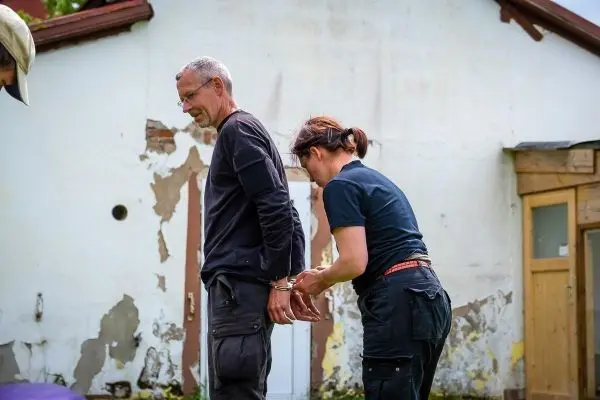 Eine Person wird von einer anderen mit Handschellen gefesselt