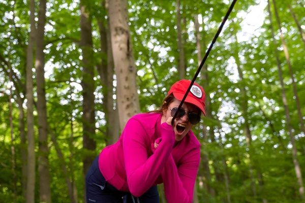 Frau zieht an einem Seil in einem Waldgebiet