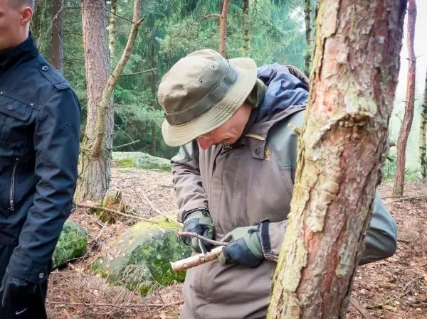 Messer bearbeitet Holzstück zur Herstellung von Zunder im Wald