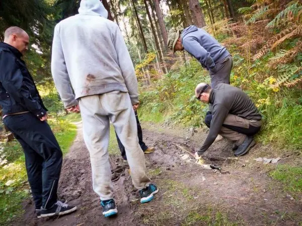 Personen untersuchen den Bodenweg und arbeiten an einer kleinen Konstruktion