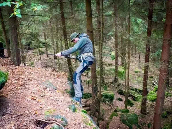 Seilquerung über einen Abhang im Wald mit gesichertem Seil