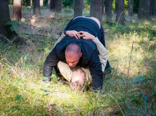 Zwei Personen im Bodenkampf auf dem Waldboden