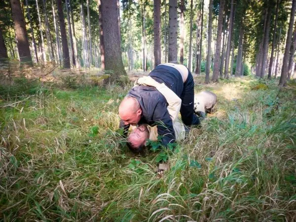Zwei Personen liegen im Gras und führen eine körperliche Auseinandersetzung durch