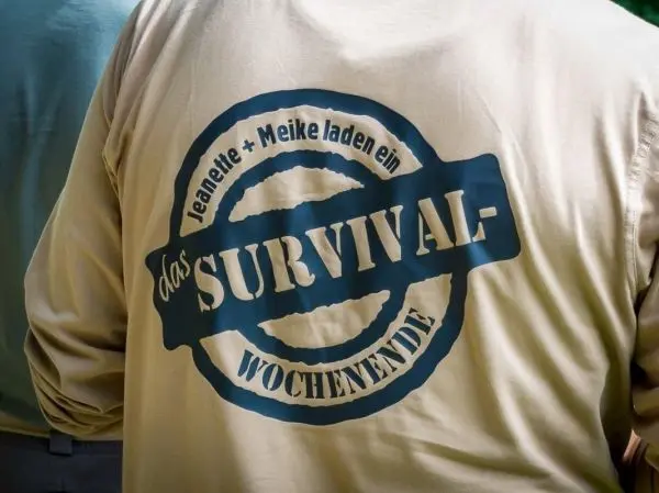 Beige Shirt mit Aufdruck „das SURVIVAL-Wochenende“ auf dem Rücken