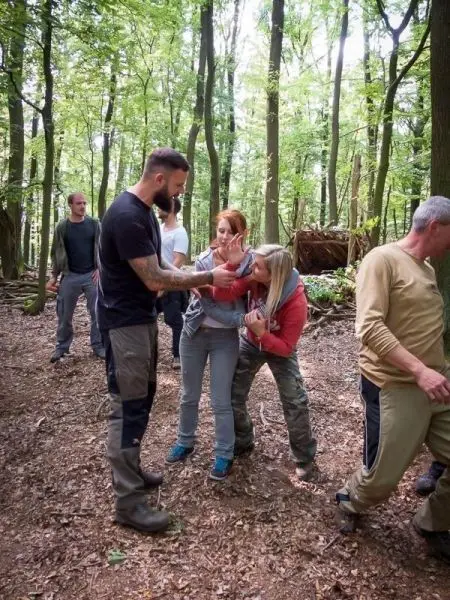 Gruppentraining im Wald mit mehreren Personen, die verschiedene Techniken üben