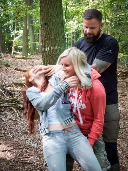 Person hält andere Person im Wald fest