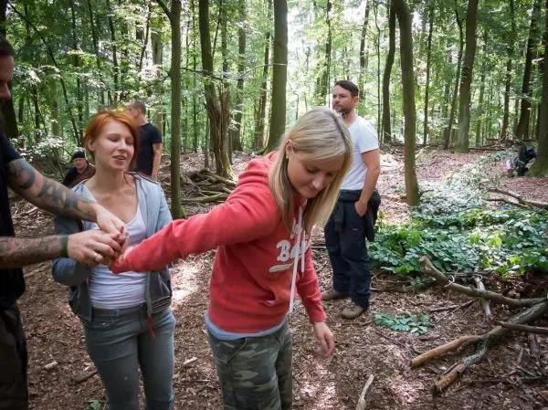 Person hilft anderer Person beim Gehen im Wald