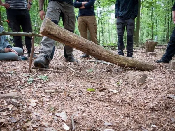 Person zeigt eine selbstgebaute Wippe im Wald