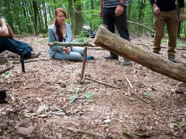 Schlagfalle (Figure-Four) mit Holzstück und Auslöser im Wald aufgebaut