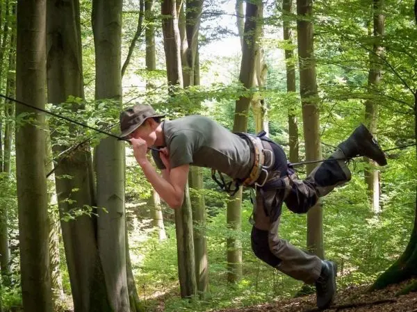 Seilquerung mit selbstgebauter Seilbrücke zwischen Bäumen im Wald