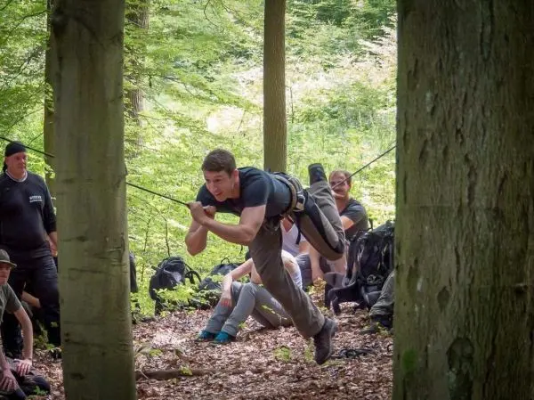 Selbstgebaute Seilquerung wird von einem Teilnehmer überquert