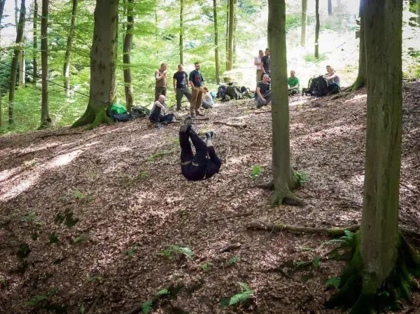 Selbstgebaute Seilquerung wird von einer Person überquert, während andere zuschauen