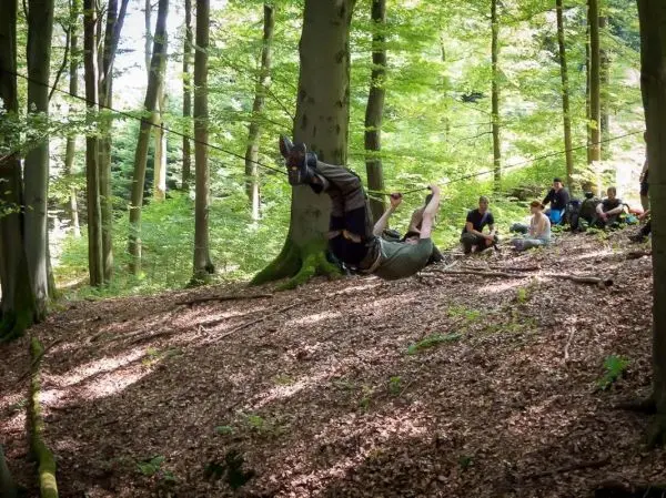 Selbstgebaute Seilquerung wird von einer Person überquert, während andere zuschauen