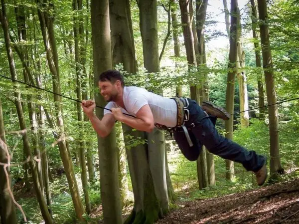 Selbstgebaute Seilquerung wird zwischen Bäumen überquert