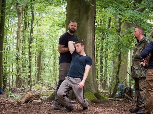 Zwei Personen demonstrieren eine Technik zur Unterstützung in einem Waldgebiet