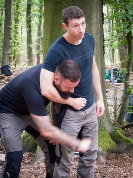 Zwei Personen üben eine Technik zur Kontrolle in einem Waldgebiet