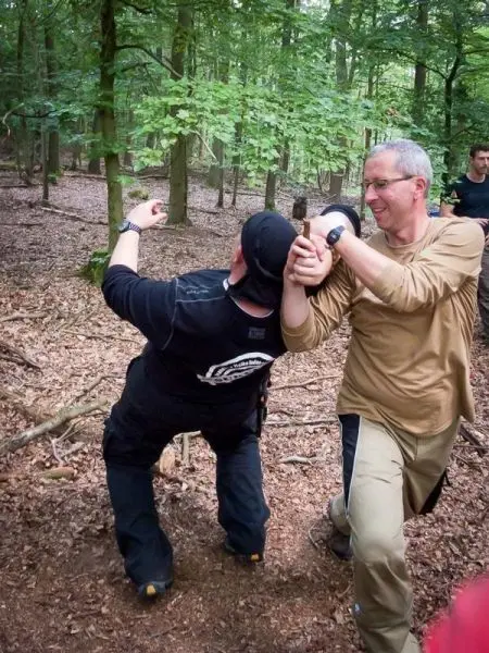 Zwei Personen üben eine Technik zur Kontrolle in einem Waldgebiet