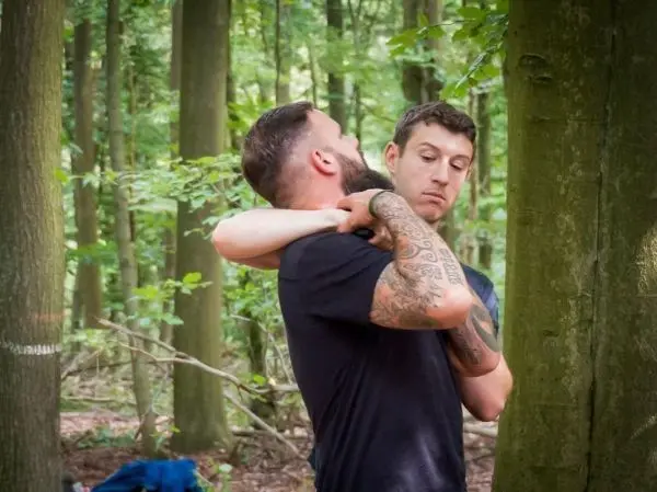 Zwei Personen üben eine Technik zur Kontrolle in einem Waldgebiet