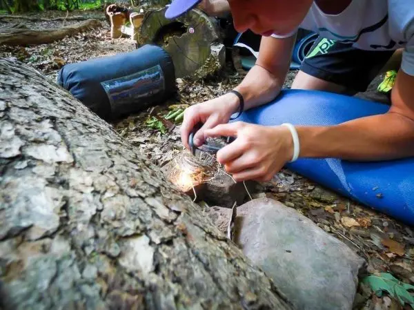 Feuerstahl erzeugt Funken auf Zunder zwischen Steinen