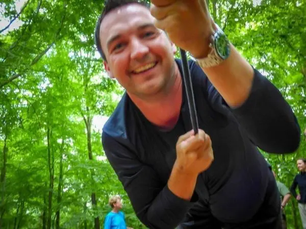 Mann zieht an einem Seil in einem Waldgebiet