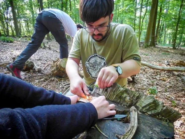 Messer schneidet Zunder auf einem Baumstamm im Wald
