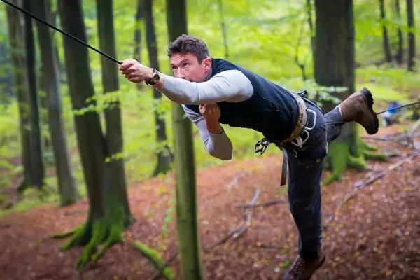 Selbstgebaute Seilquerung wird zwischen Bäumen überquert