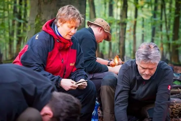 Zunder wird vorbereitet, während eine kleine Flamme brennt