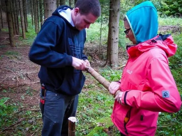Messer bearbeitet Holzstück, während eine Person das Werkstück hält