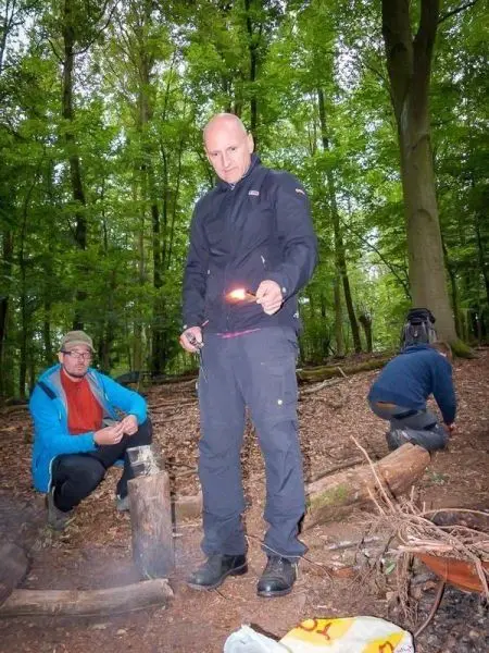 Feuerstahl erzeugt Funken über Zunder in einem Waldgebiet