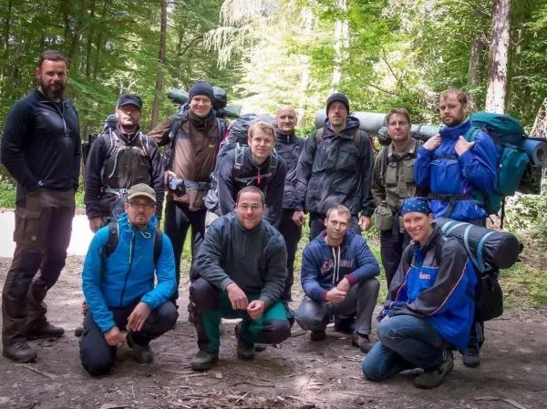 Gruppe von Personen mit Rucksäcken im Wald beim Überlebenstraining