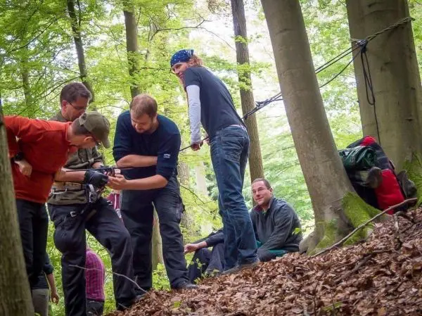 Gruppierung von Personen in einem Wald, die Ausrüstung überprüfen und besprechen
