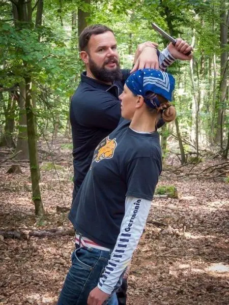Kampftraining mit einem Messer in einem Waldgebiet
