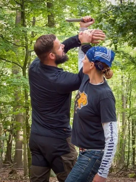 Kampftraining mit einem Messer in einem Waldgebiet