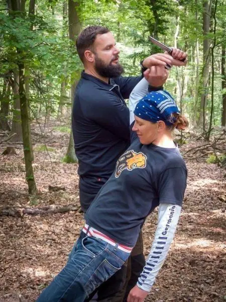 Person demonstriert eine Selbstverteidigungstechnik im Wald
