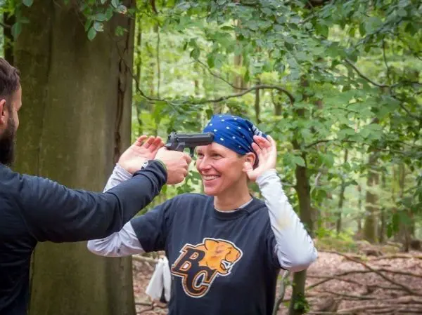 Person hält eine Pistole an den Kopf einer anderen Person