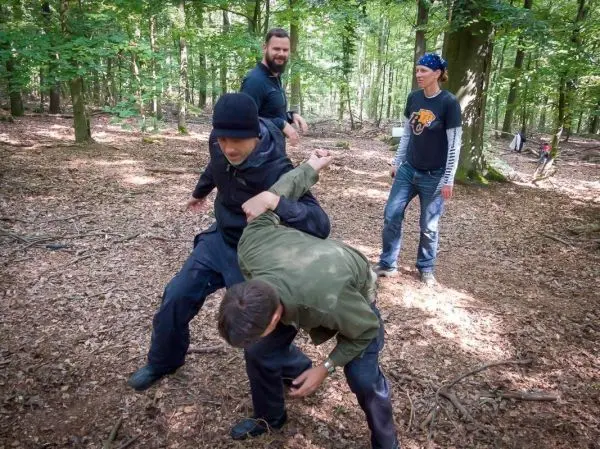 Person zeigt Technik zur Selbstverteidigung im Wald